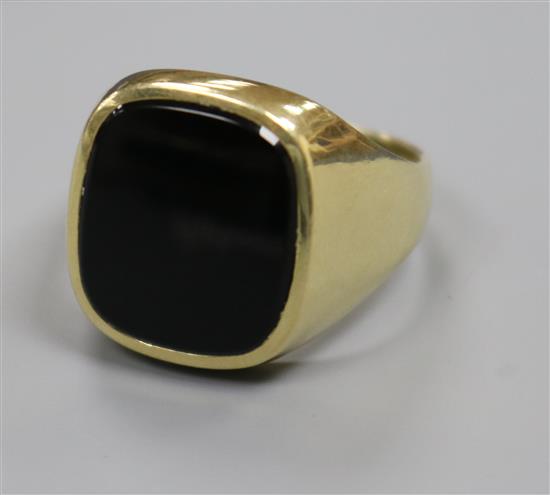 A 585 yellow metal and black onyx signet ring, size T.